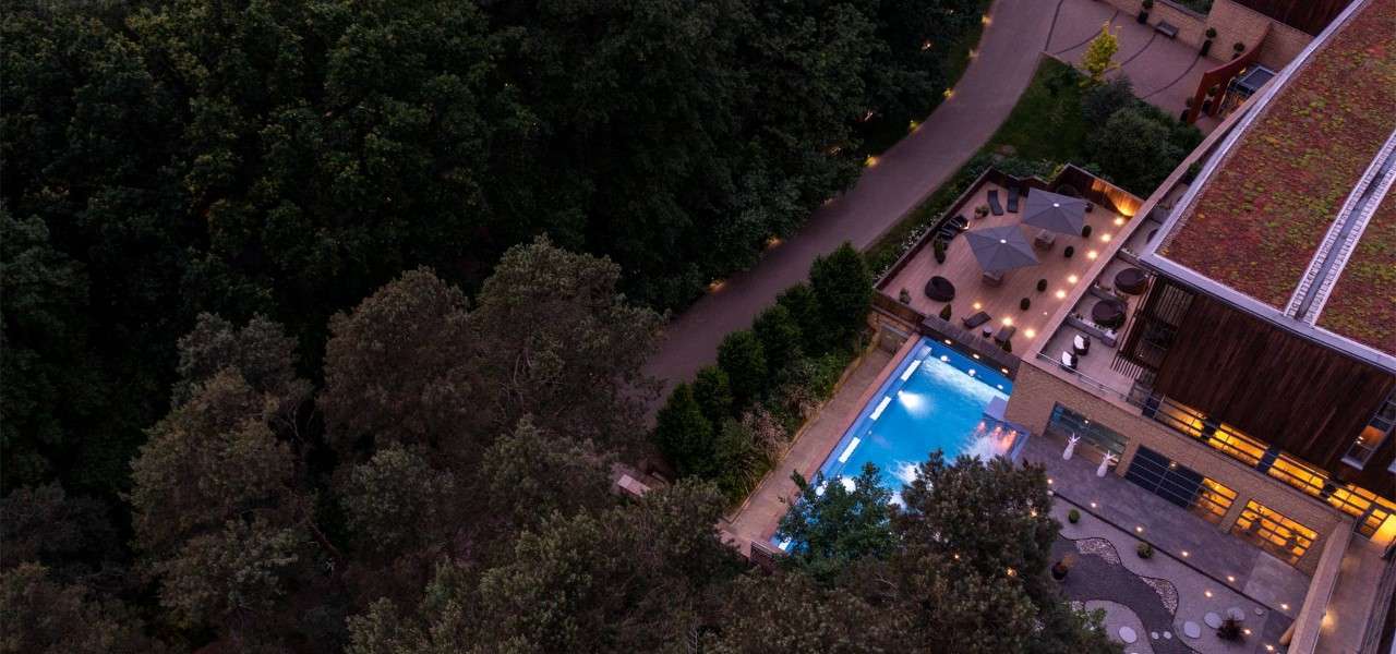 Aerial shot of an outdoor pool surrounded by woodlands
