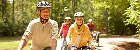 A family cycling through the forest.