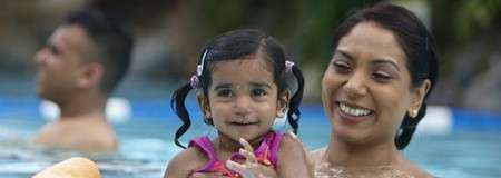 Woman holding a young girl in the pool