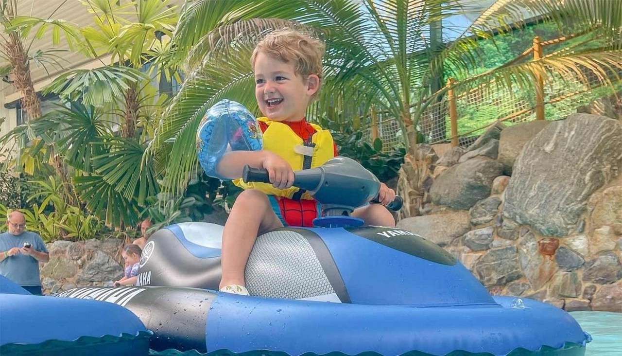 A boy on an inflatable mini jet ski in the Subtropical Swimming Paradise.