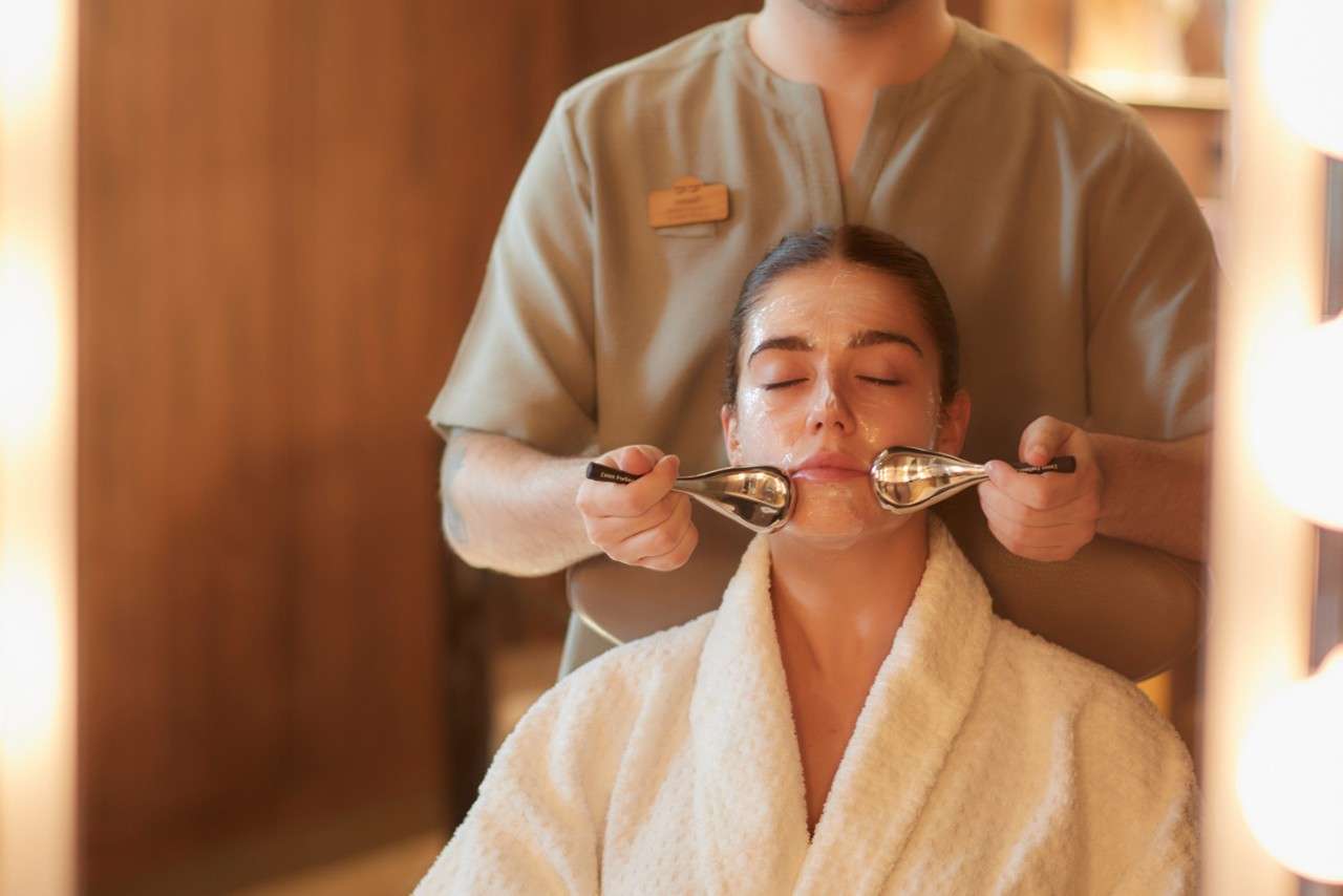 A lady with a face mask on and eyes closed having a facial treatment.
