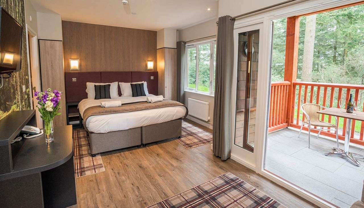 The bedroom in a hotel room with the sliding balcony doors open.