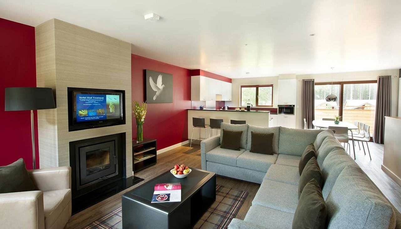 The living and dining area, in view is a large corner sofa and fire.