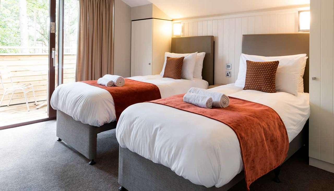 Two twin beds inside an adapted lodge. 