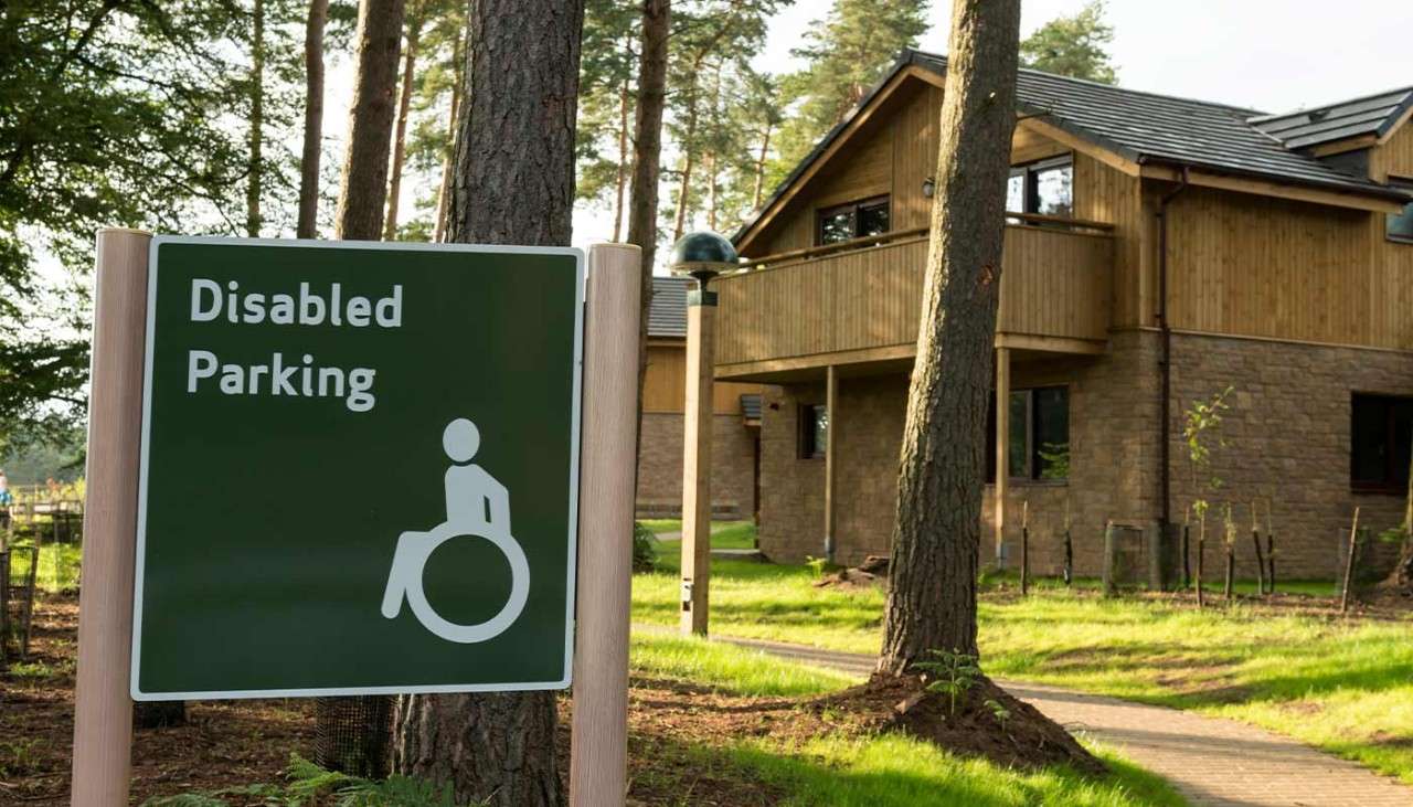 A disabled parking sign outside of a lodge. 