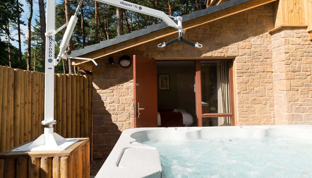 A hoist over the top of an outdoor hot tub. 