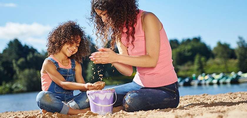 Mother and daughter playing on the beach