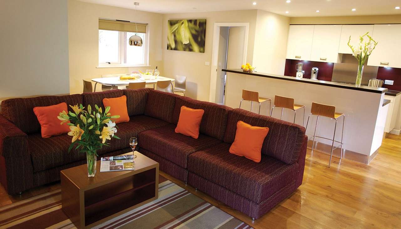 A corner sofa and bar style counter top in an Executive living and kitchen area