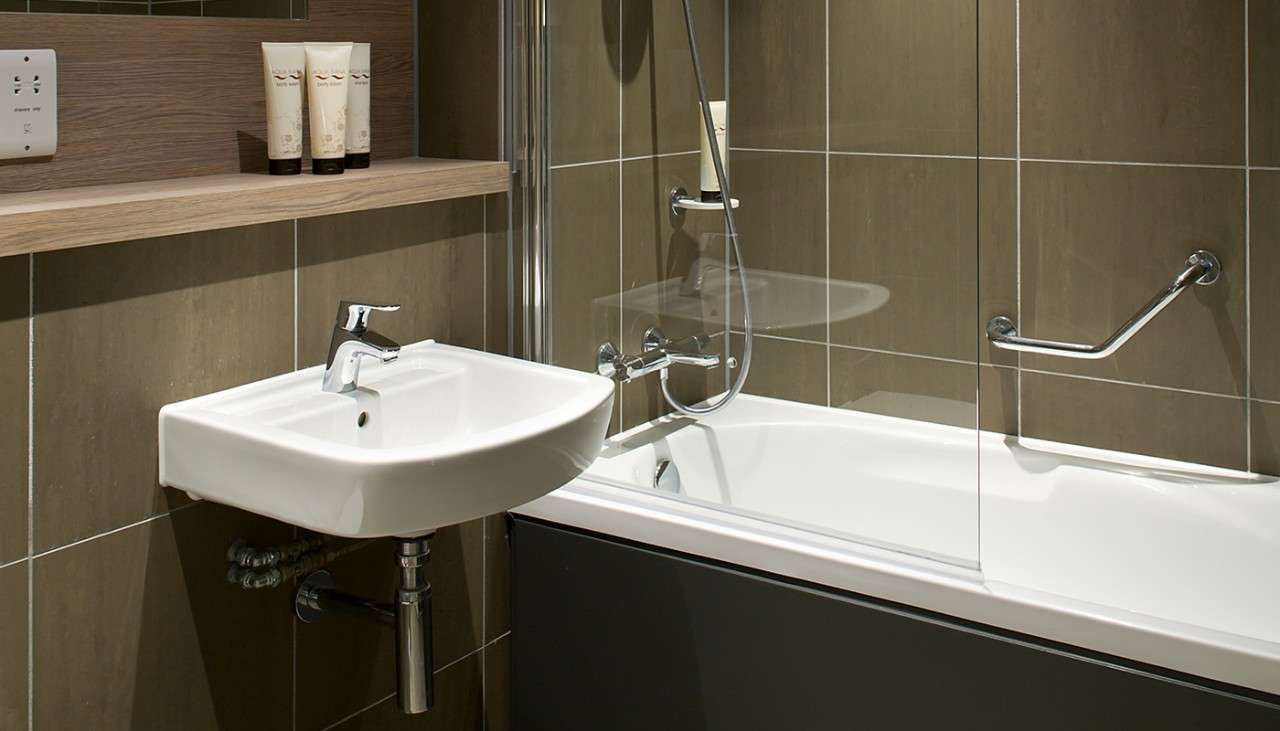 A bathtub and sink in the bathroom of an Executive Lodge