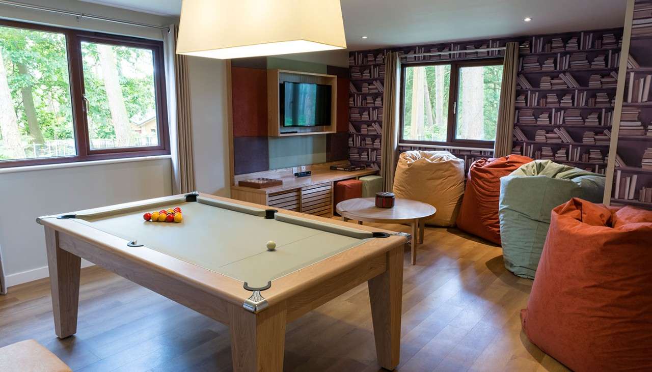 A games room in an Exclusive lodge with a pool table and bean bags 