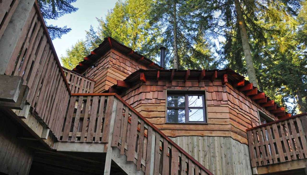 A neatly made double bed and wardrobe in a Treehouse bedroom
