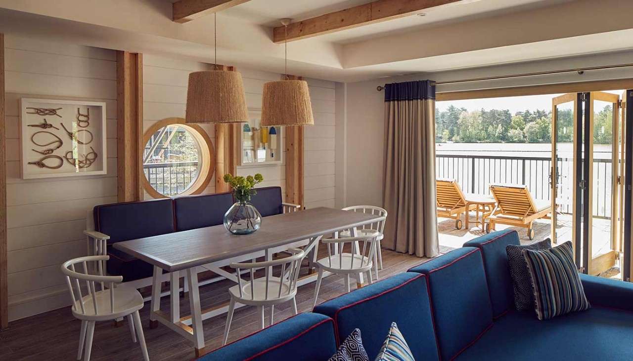 A dining table and blue sofa in a Waterside Lodge