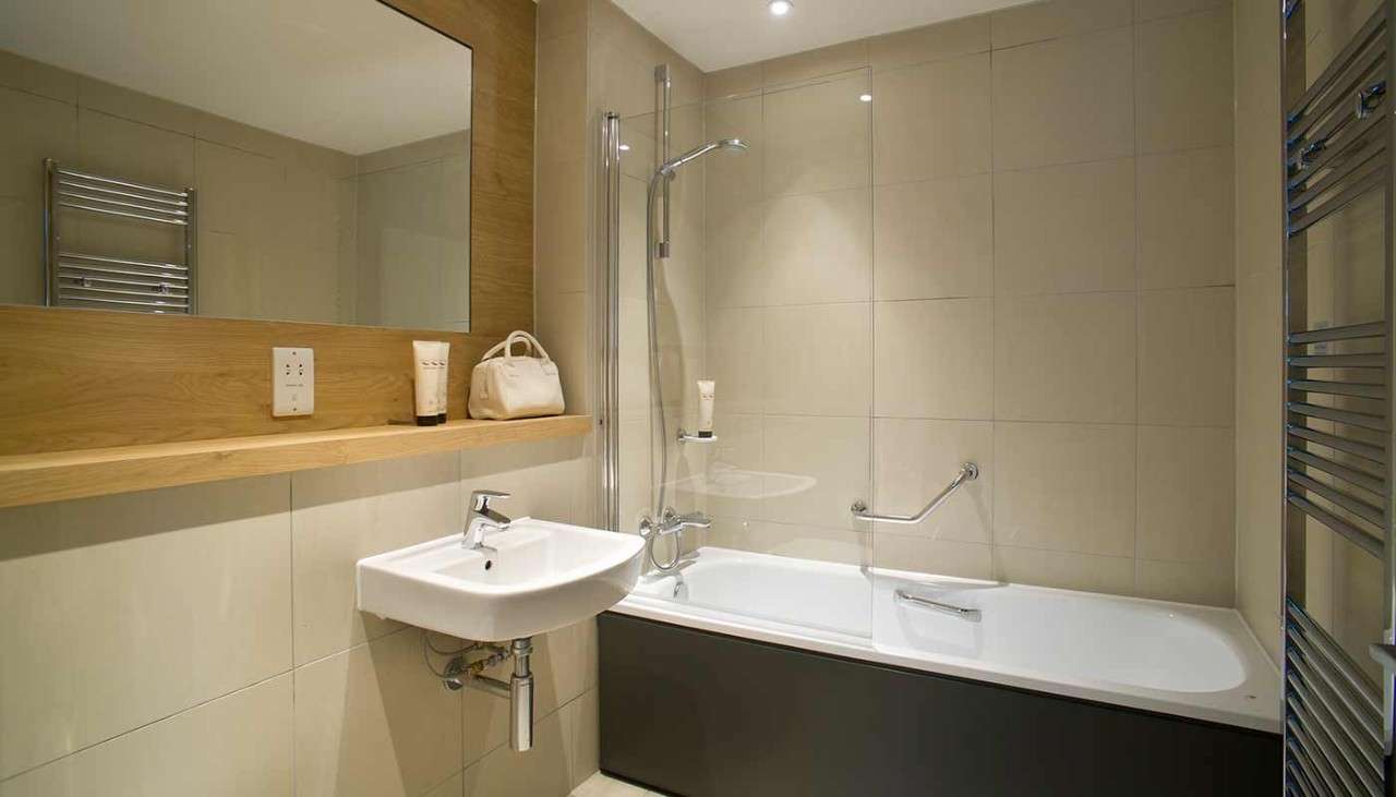 A bathtub, sink and mirror in a Woodland Lodge bathroom