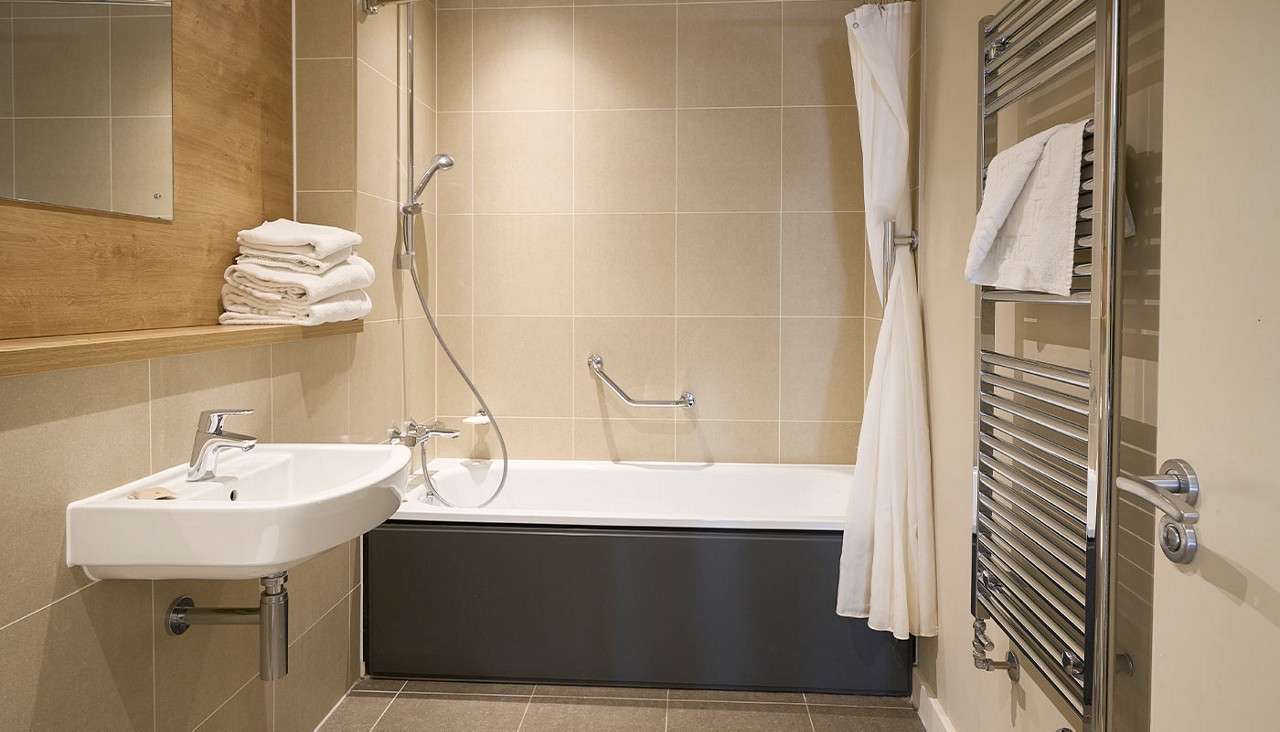 A bathtub, sink and mirror in a Woodland Lodge bathroom