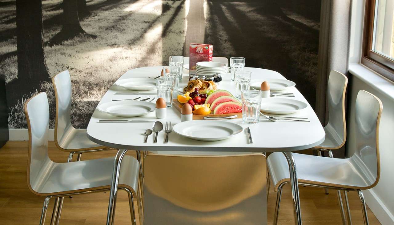 A dining table laid for breakfast in a Woodland Lodge