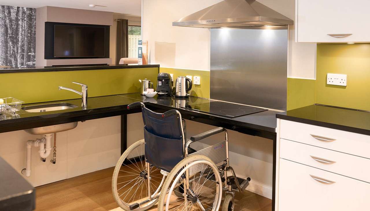 Lowered kitchen worktops with wheelchair underneath.