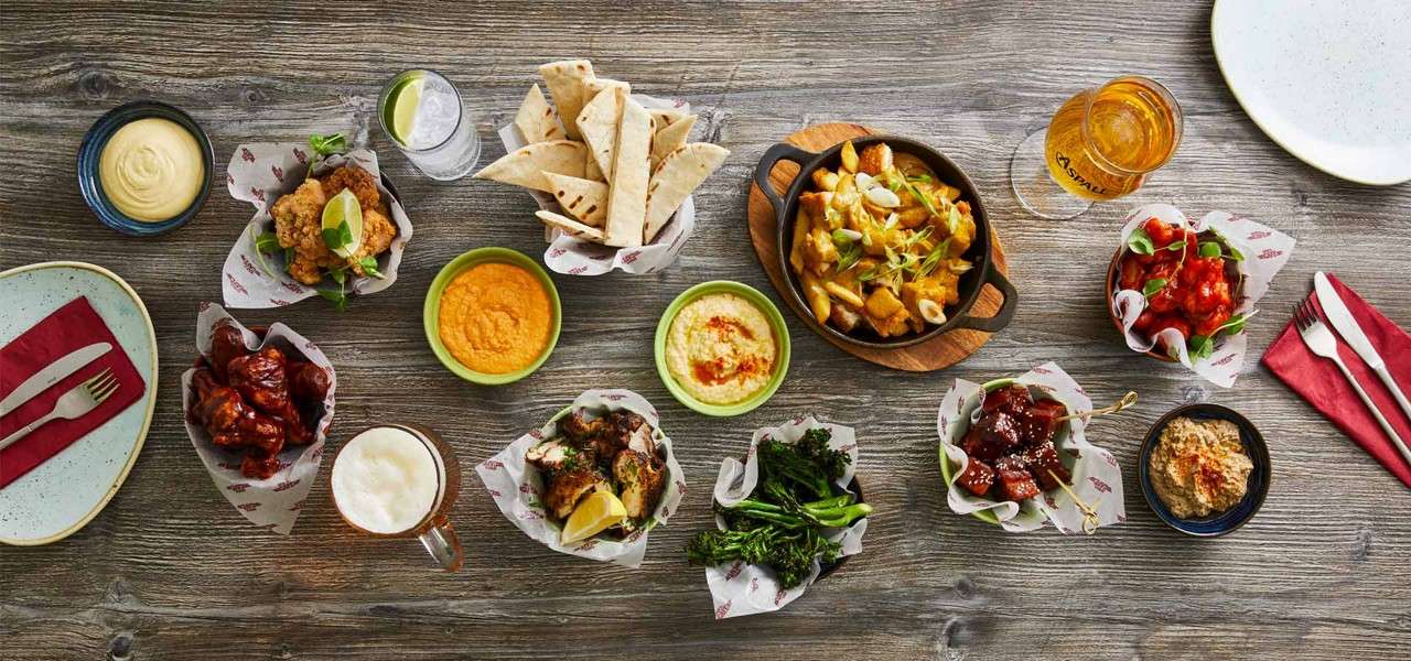 a selection of dishes including loaded fries and chicken wings