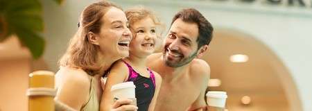 A family stood having a coffee from Starbucks.