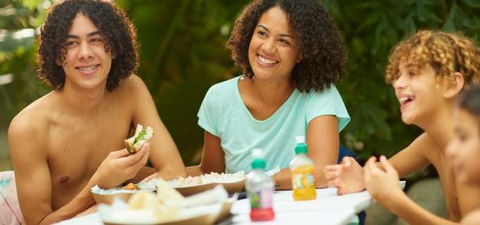 A family sitting around a table enjoying snacks and drinks