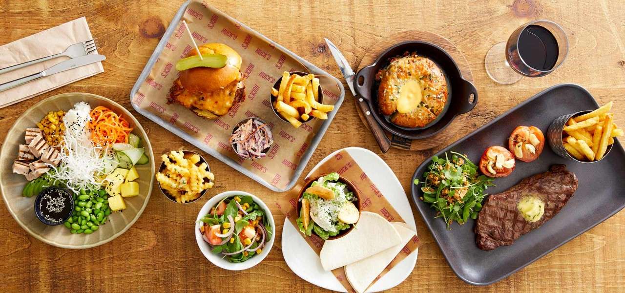 Selection of dishes including steak, garlic bagel bread, and salad