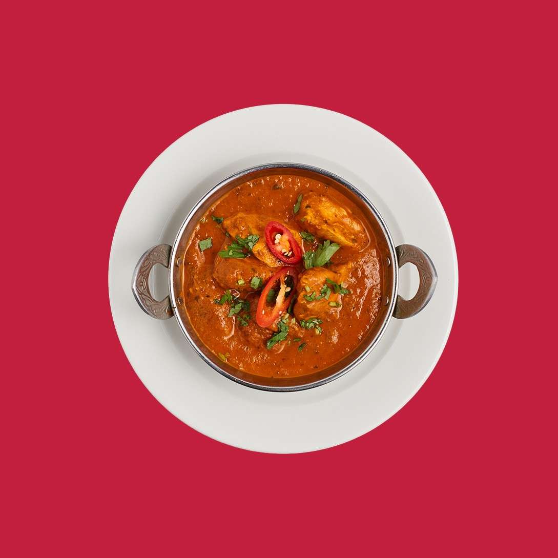 Chicken madras served with sliced chilli in a traditional bowl.