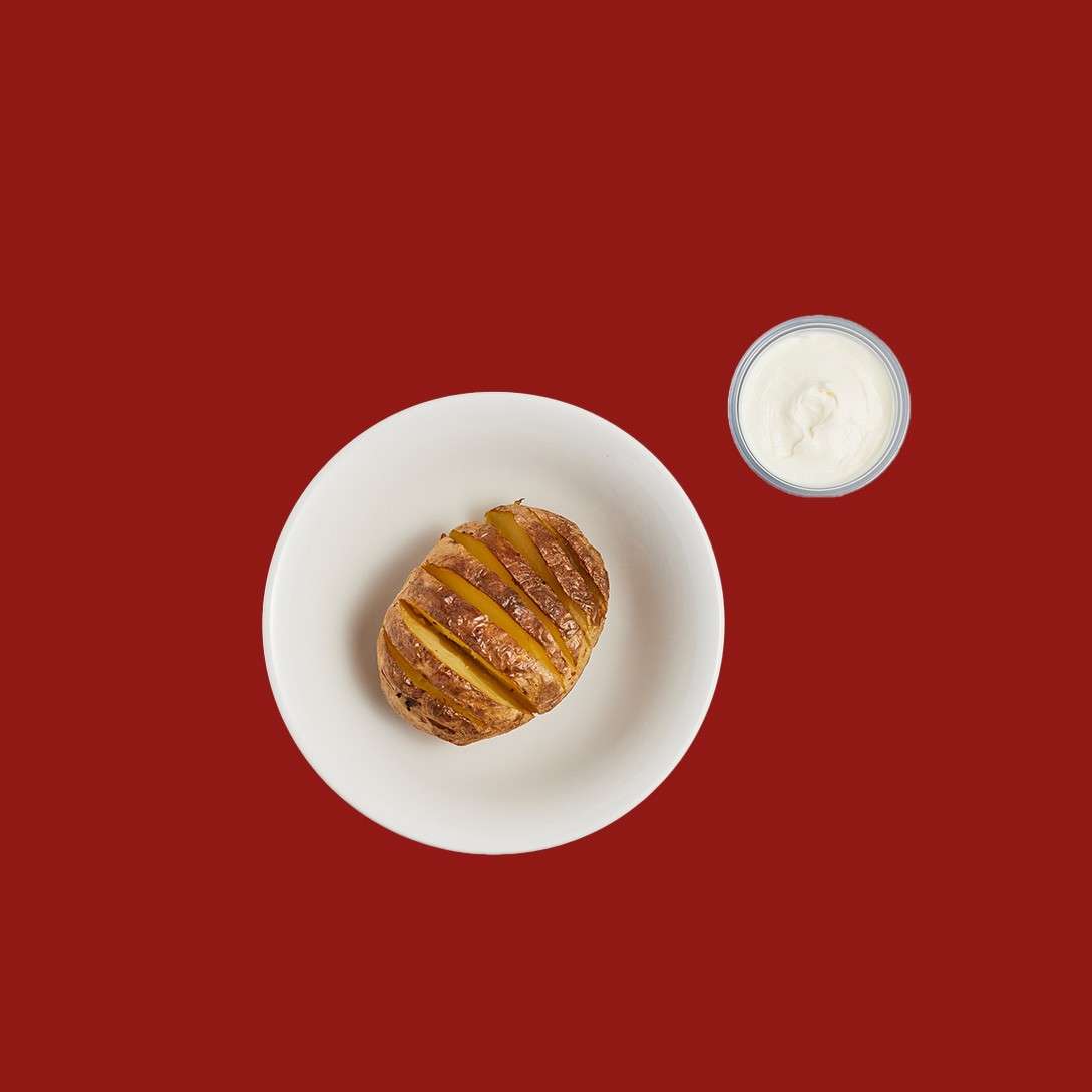 Sliced baked potato with a creamy sauce.