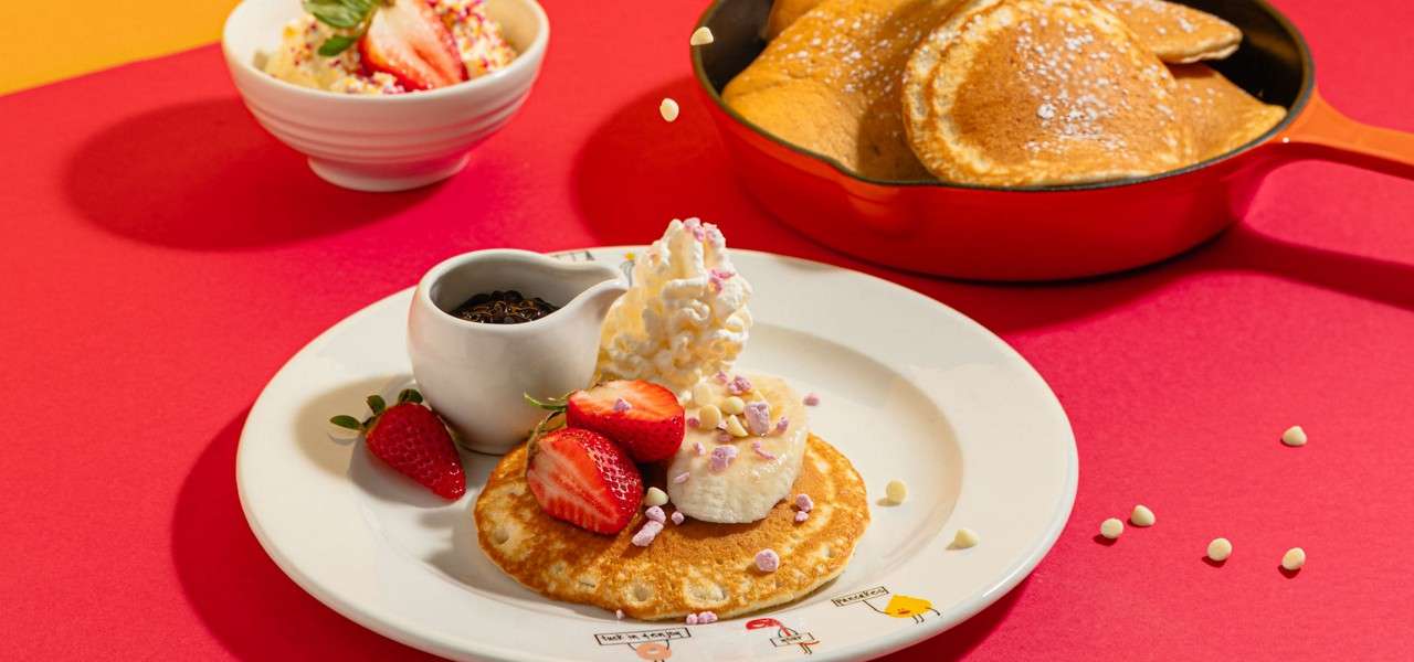 Pancake topped with whipped cream and strawberries.
