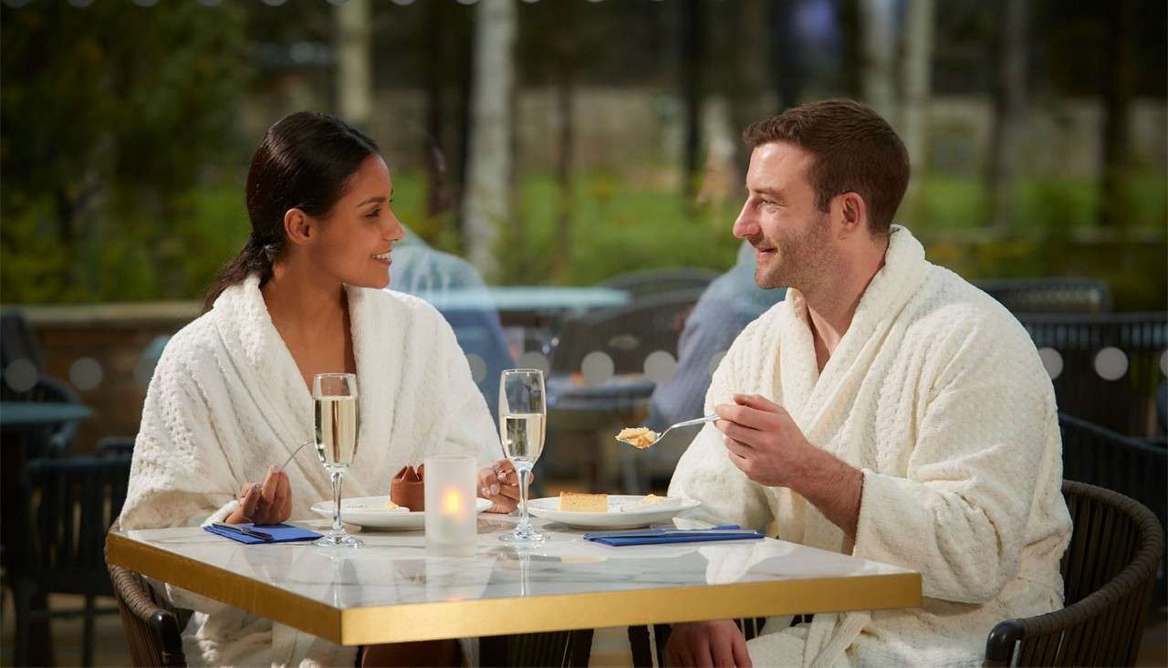 Couple sitting at a table in the Vitalé Café Bar enjoying drinks and dessert.