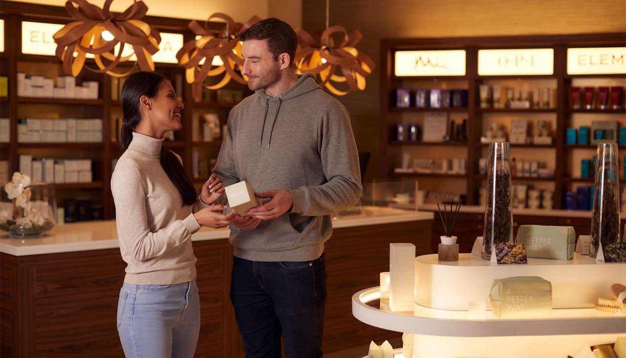 Couple standing in the Aqua Sana Boutique looking at the products available. 