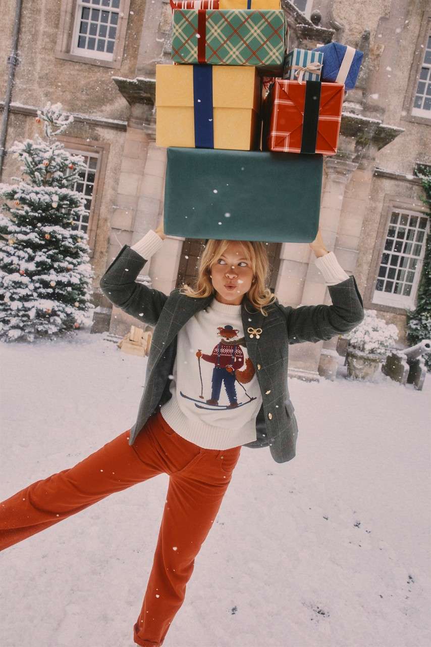 Woman modelling Joules clothing whilst carrying presents.