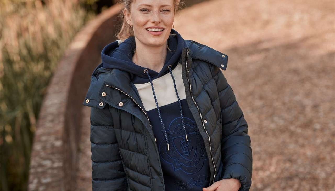 Woman standing wearing Joules clothing.
