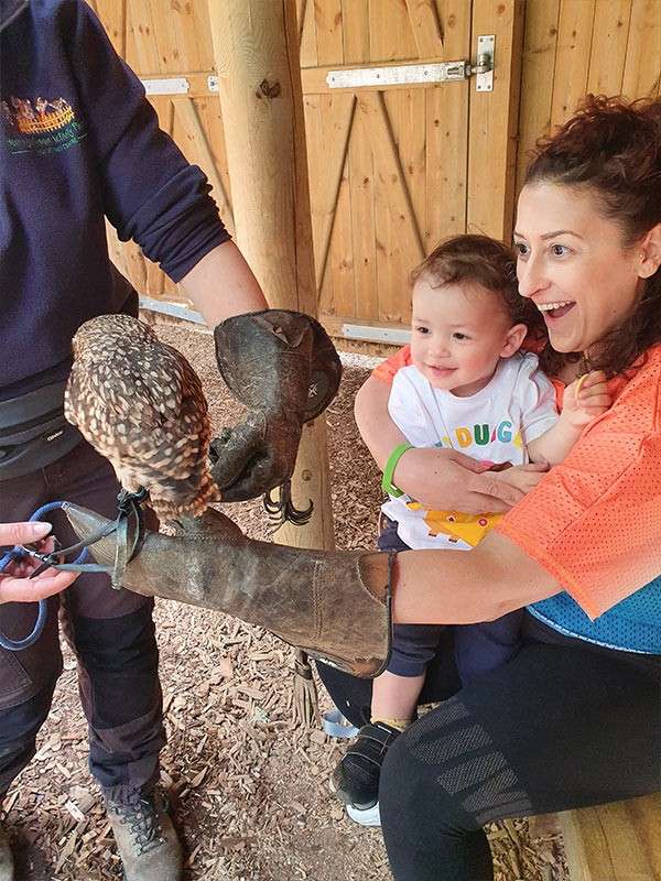 A mother holding her baby and an owl.