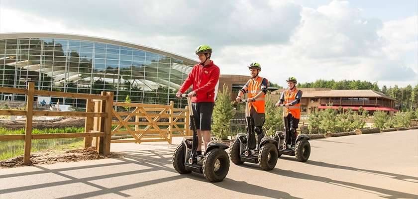 Three people riding segways on the paths through the village. 