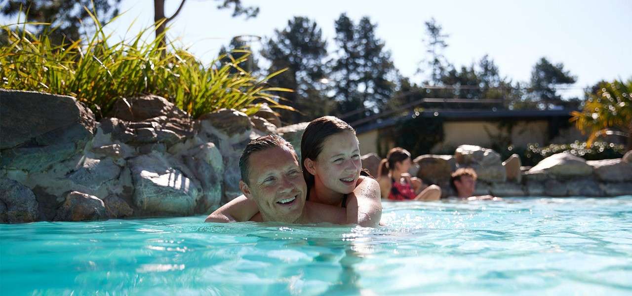 Father with his daughter on his back in the Outdoor Pool in the Subtropical Swimming Paradise.