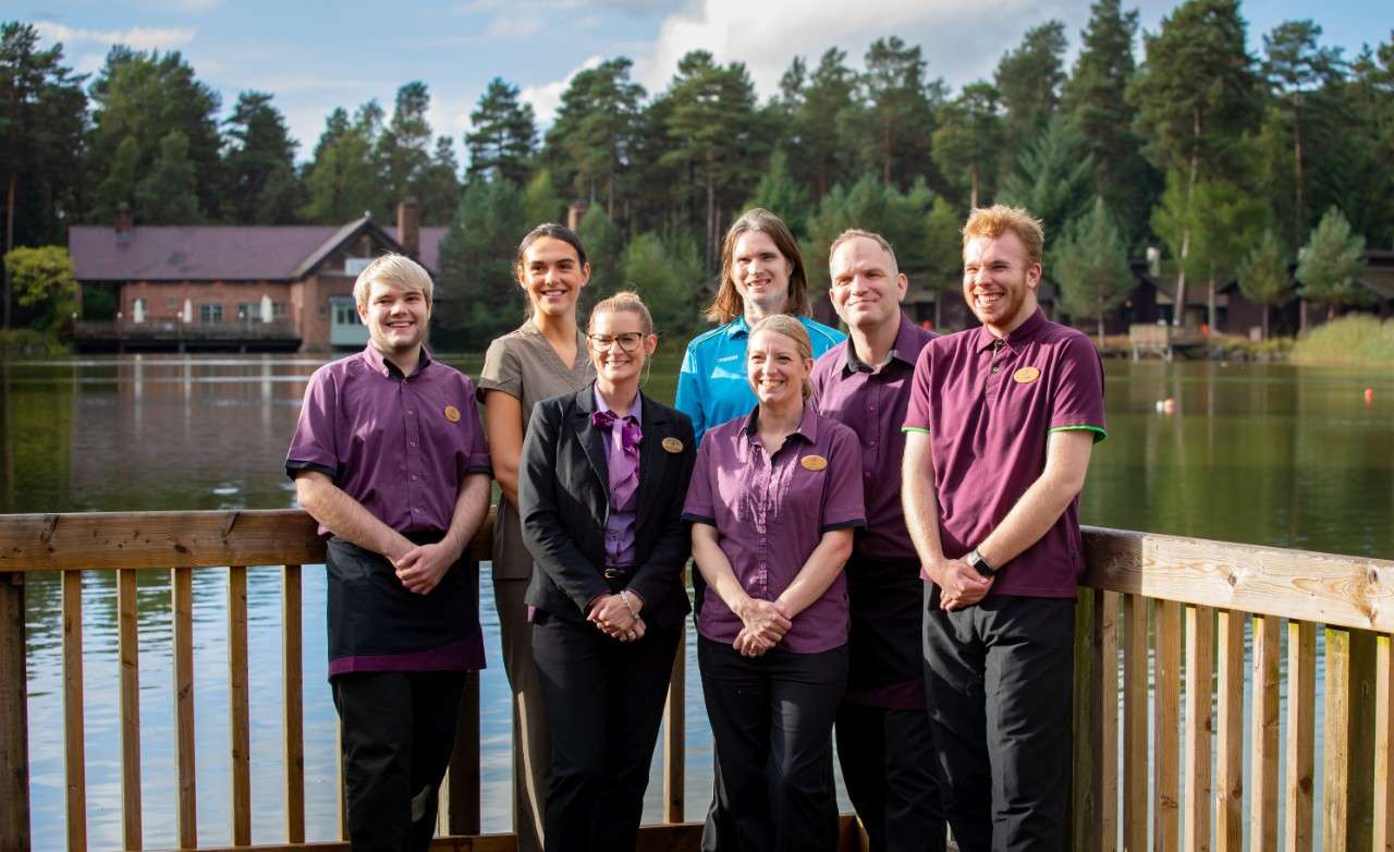 Staff members stood together next to the lake smiling.