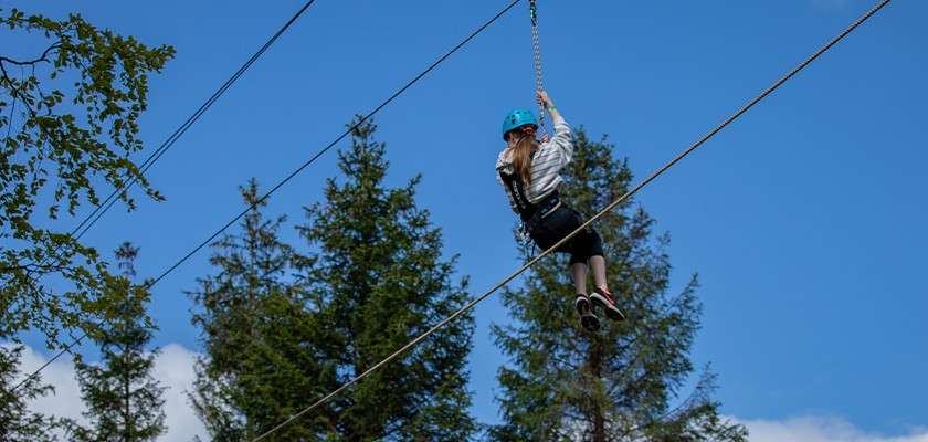 A girl on the zip wire on the Aerial Adventure activity