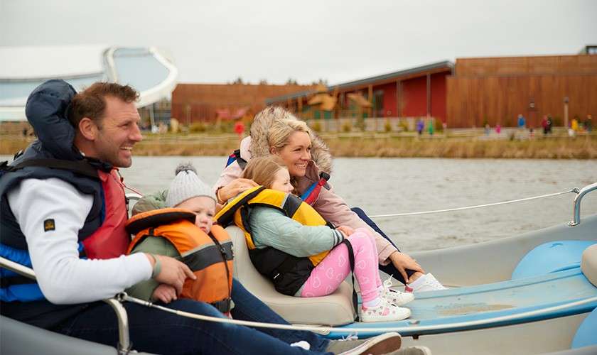 Family on an electric boat on the lake at Longford forest.