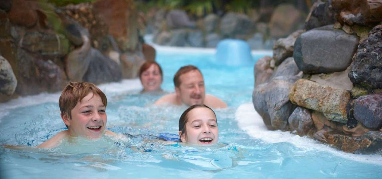 A family smiling and having fun going down the rapids in the subtropical swimming paradise