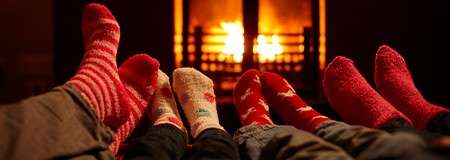 Feet wearing socks by the fire.