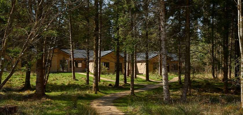 The exterior of a lodge in the forest.