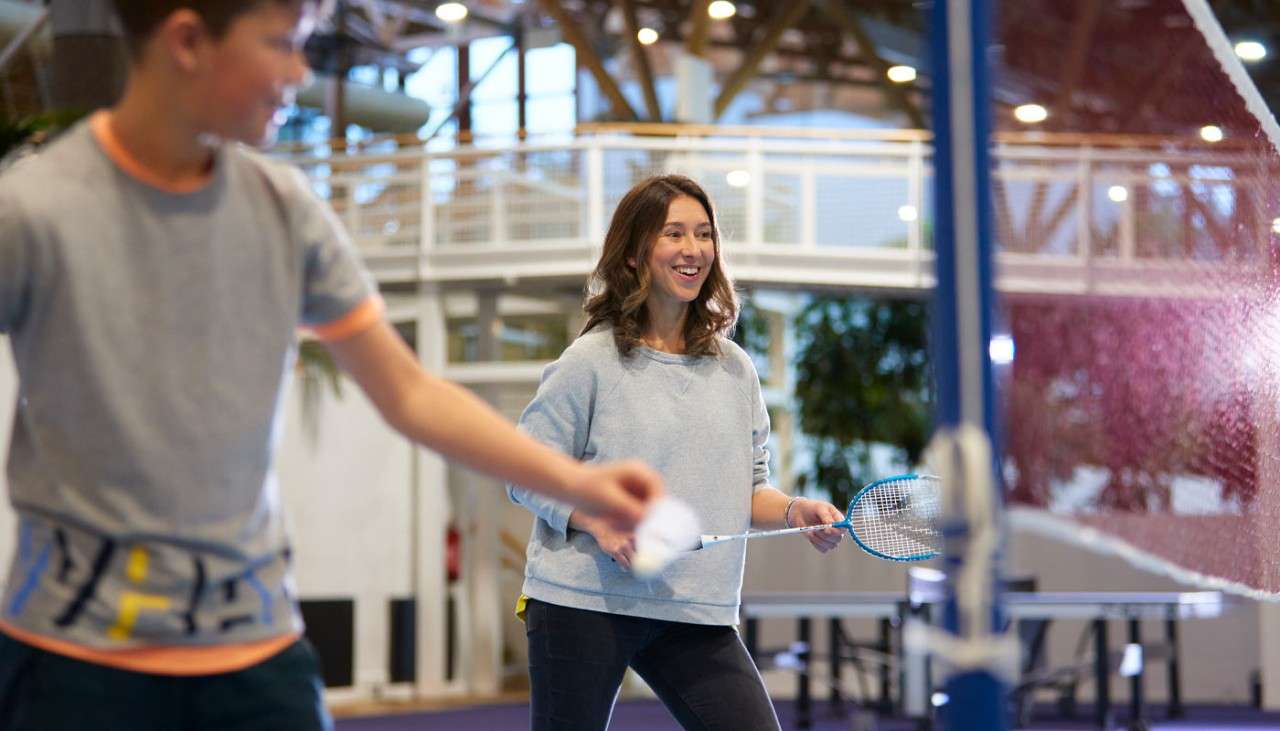 Woman and boy playing badminton