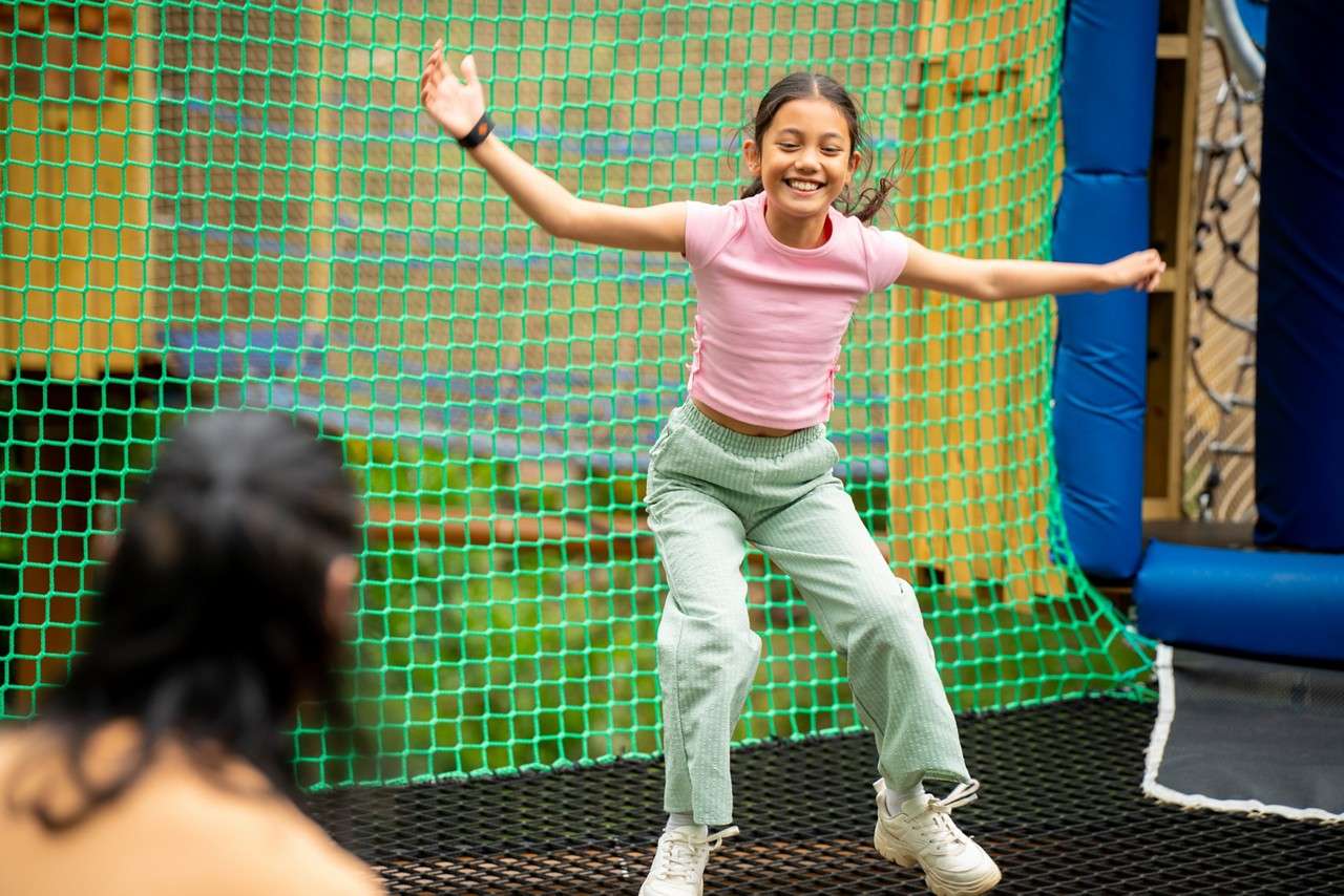 Young girl jumping in the Adventure Nets course.