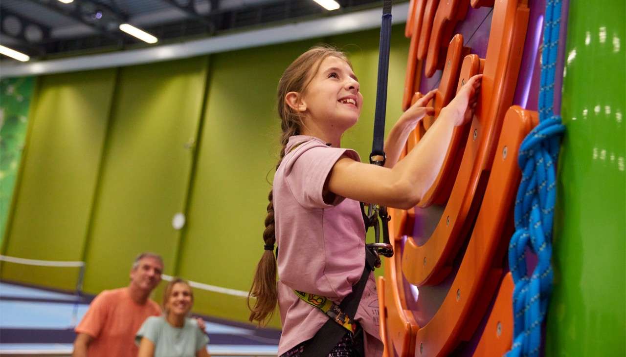 Young girl climbing an indoor climbing wall