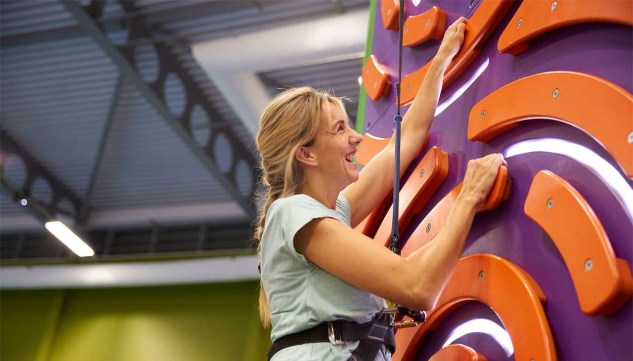 Woman holding onto an indoor climbing wall