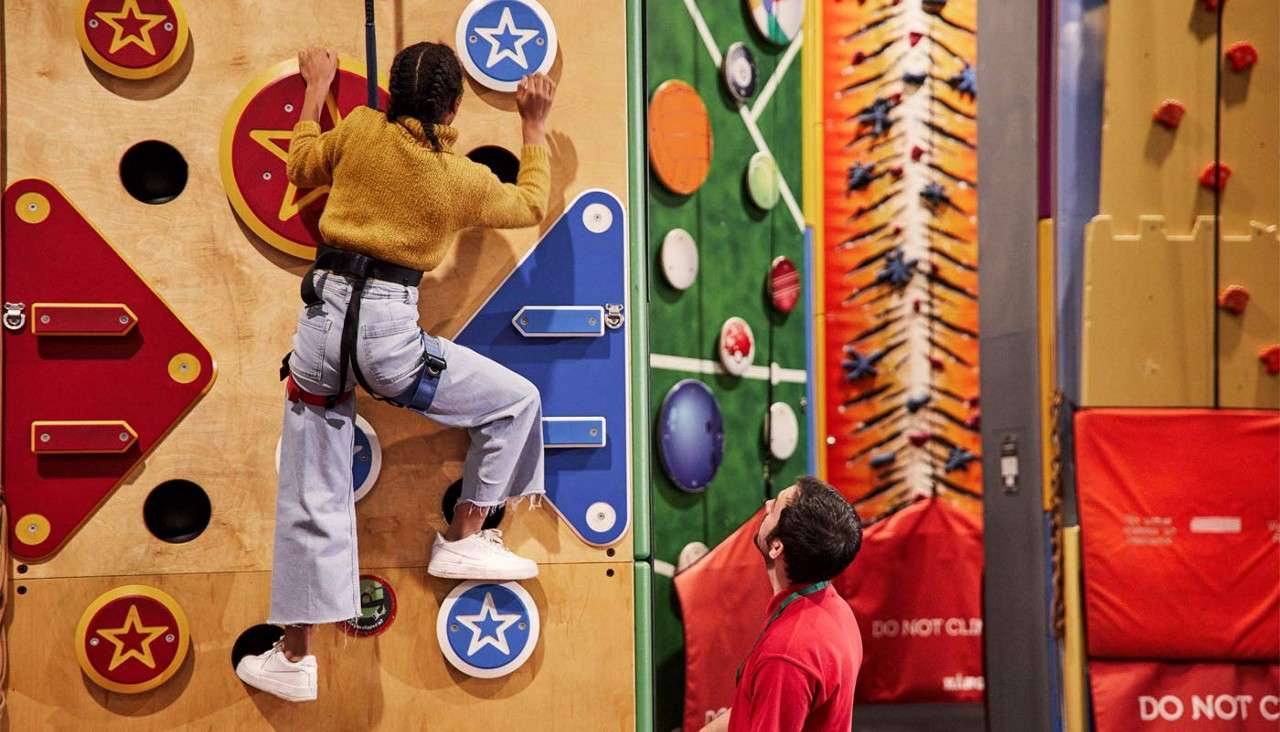 Girl scaling a climbing wall