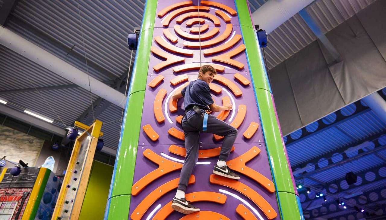 Teenage boy climbing an indoor climbing wall