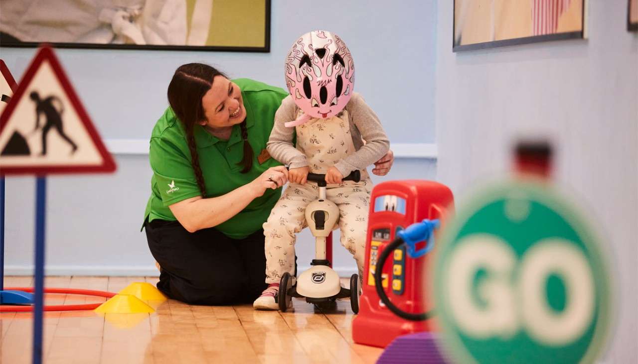 Young girl learning to use a scooter