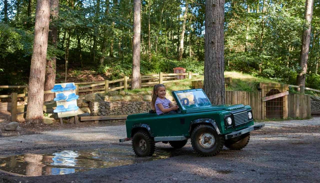 Young girl in a small car.