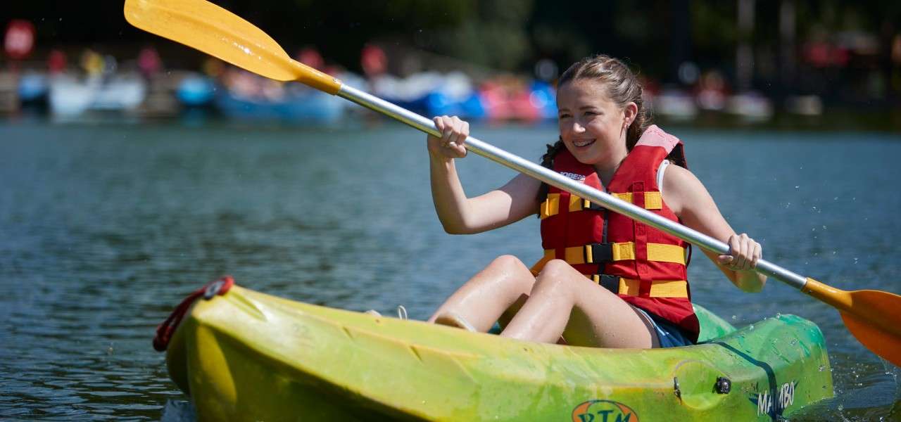 Young girl on a Single Kayak floating on the lake.