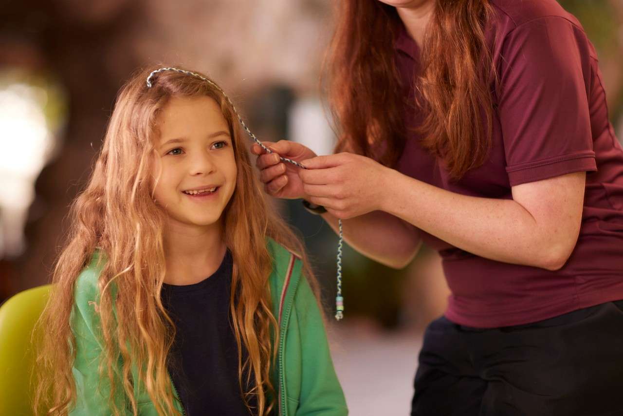 A small girl having her hair braided